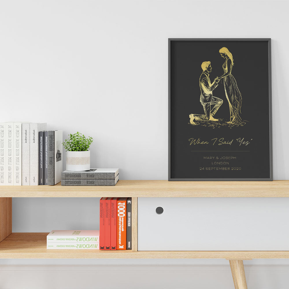 A personalised gold silhouette print of a marriage proposal with names and date.